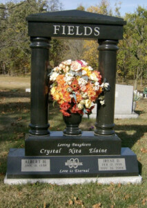 Fields pillar headstone monument with polished granite columns and engraved memorial inscription in cemetery setting